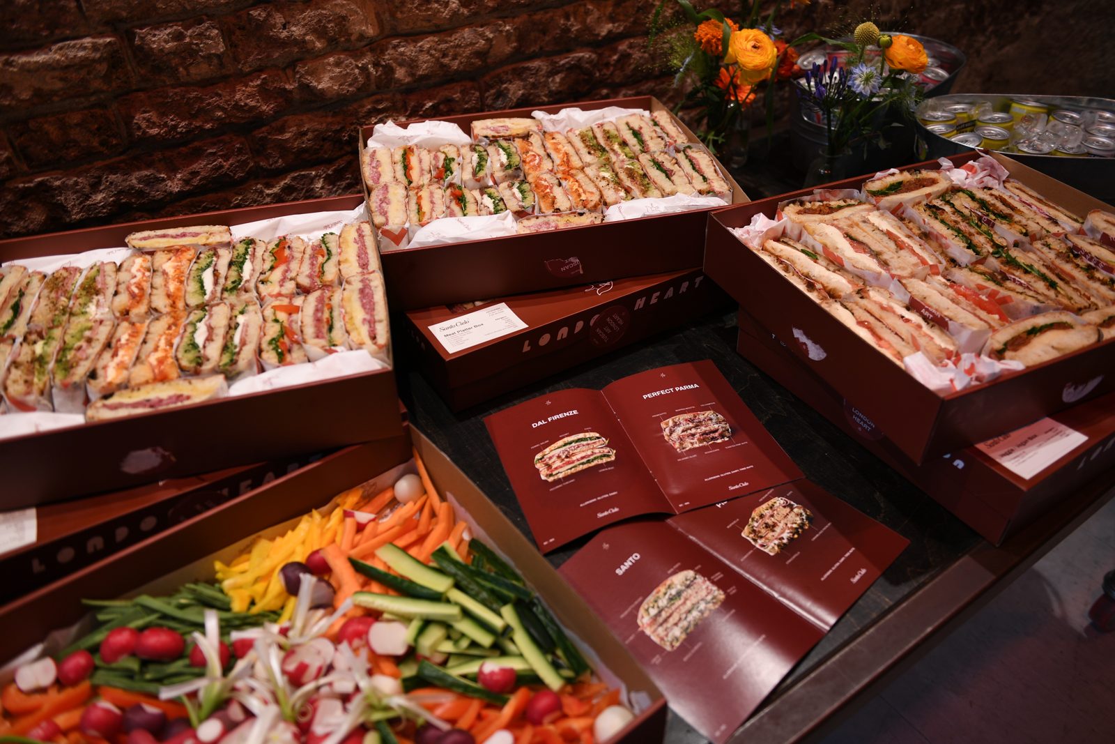 Santo Cielo platter boxes and sandwich menu booklets laid out at the Bio and Me event