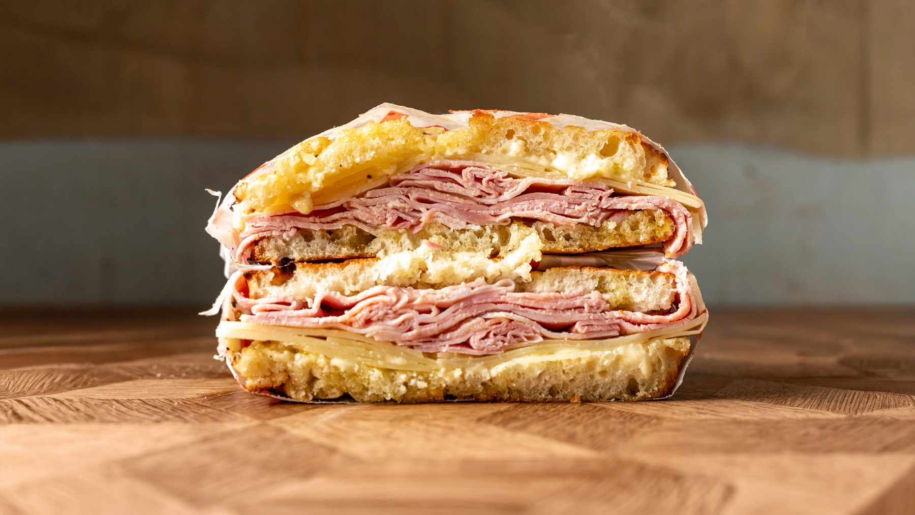 The Liguria schiacciata cut in half showing Coombeshead Farm smoked ham, asiago and parmesan aioli on Tuscan bread