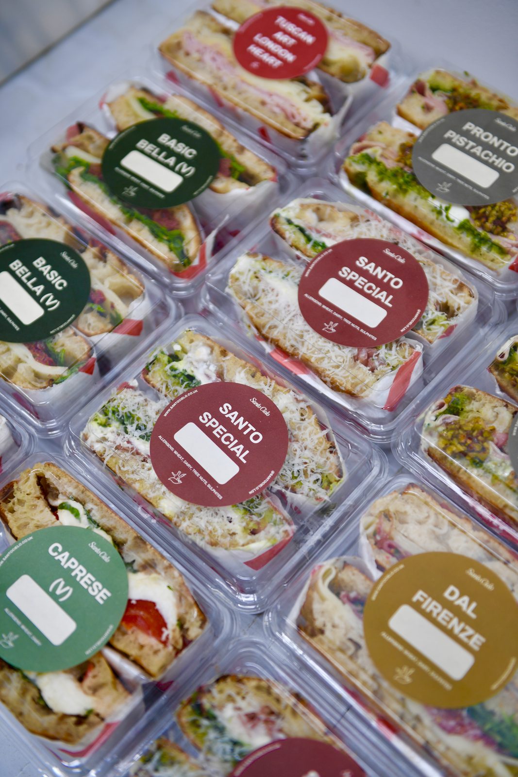 Sealed retail ready Santo Cielo sandwich packs with colour coded labels for Santo Special, Basic Bella, Caprese, Dal Firenze and Pronto Pistachio