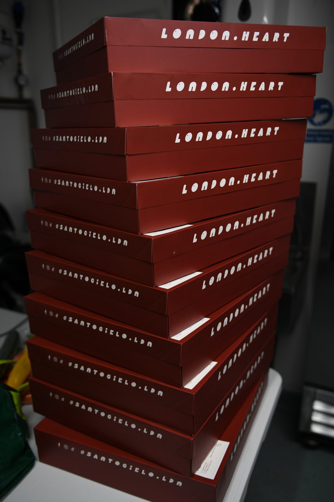 A tall stack of branded Santo Cielo wholesale delivery boxes ready to go out