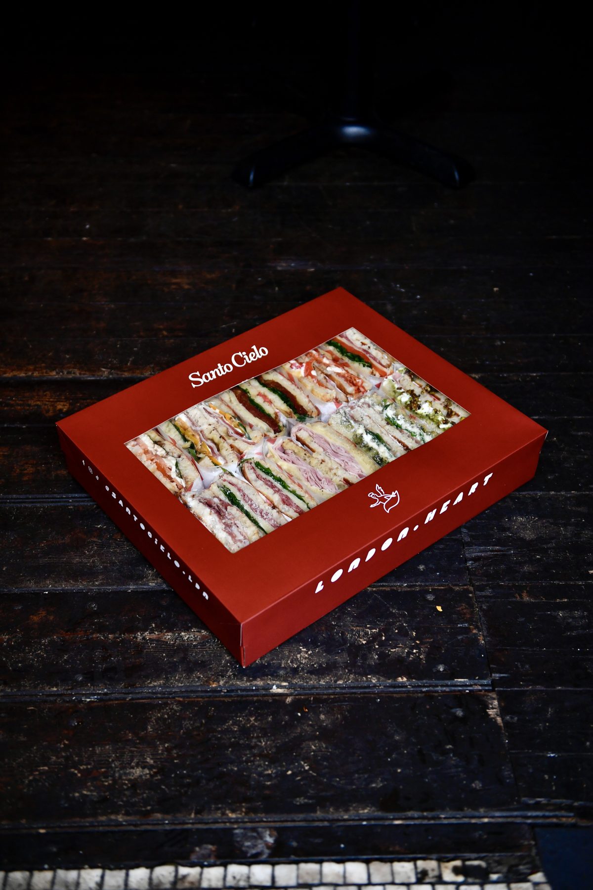 Branded red Santo Cielo platter box reading London Heart, with a window showing mixed schiacciata sandwiches inside