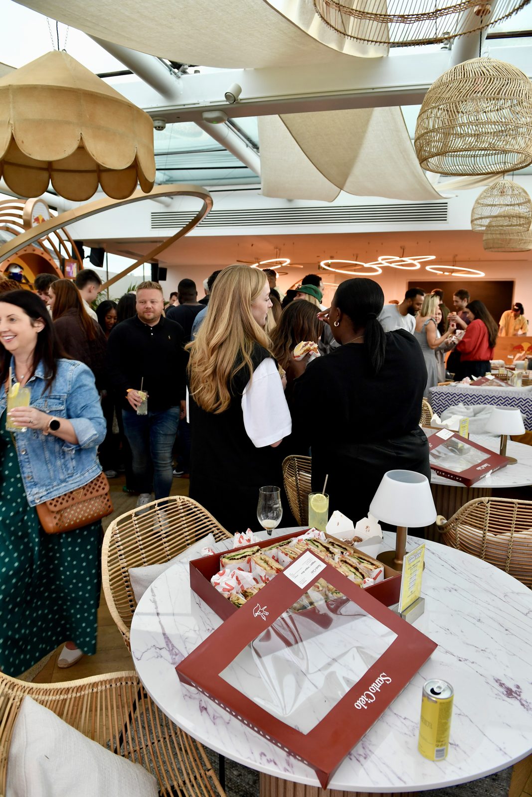 Guests mingling at the Red Bull summer party with Santo Cielo platter boxes on the tables
