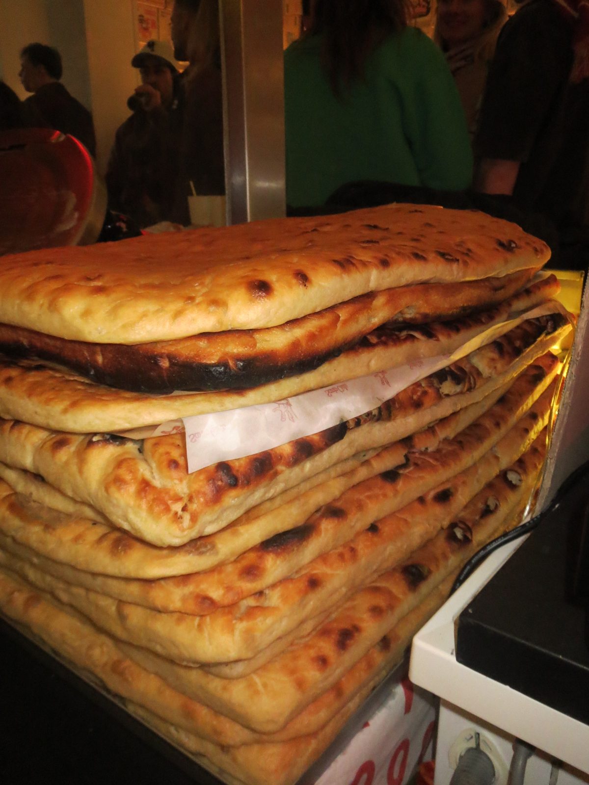 A towering stack of freshly baked schiacciata loaves at the Santo Cielo × S.A.B.A. pop up