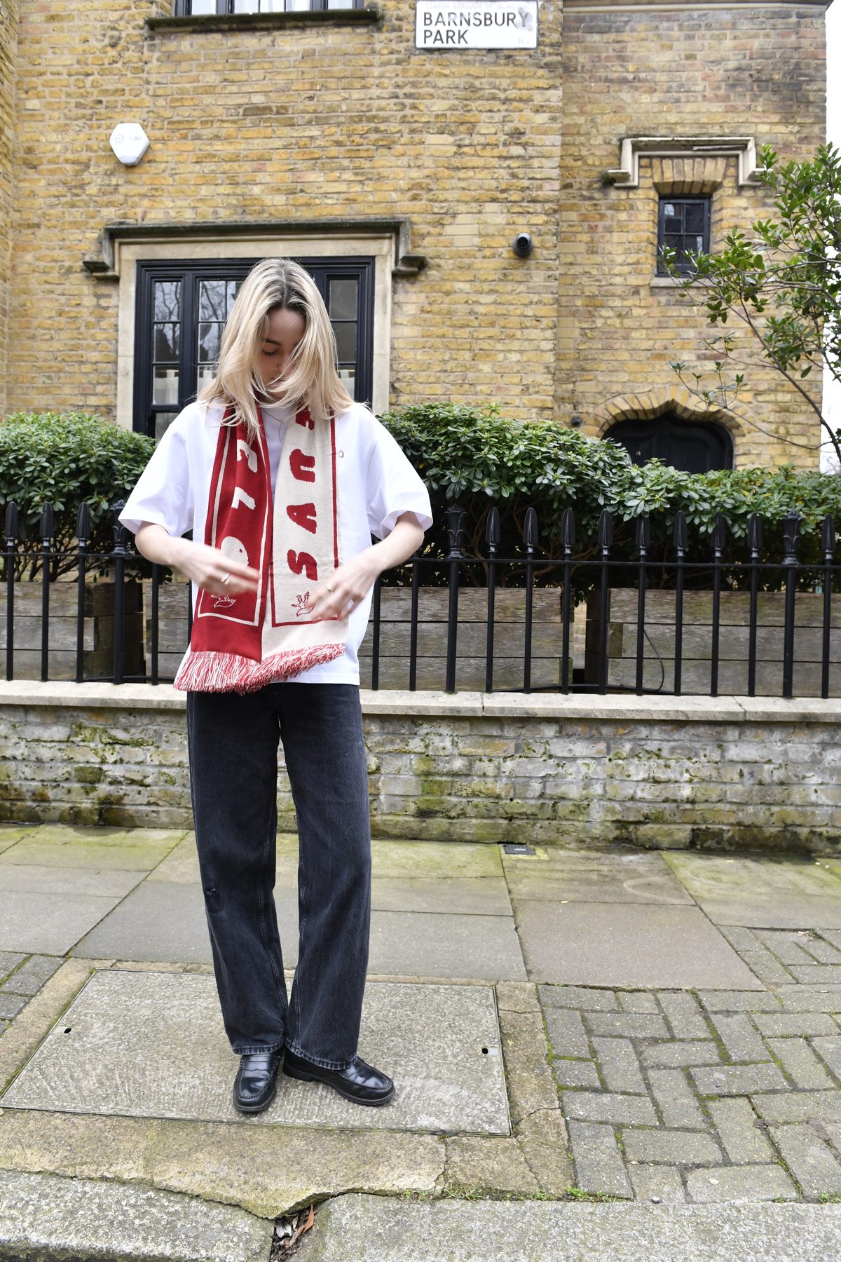 Red and cream knitted Santo Cielo OG scarf worn over a white tee