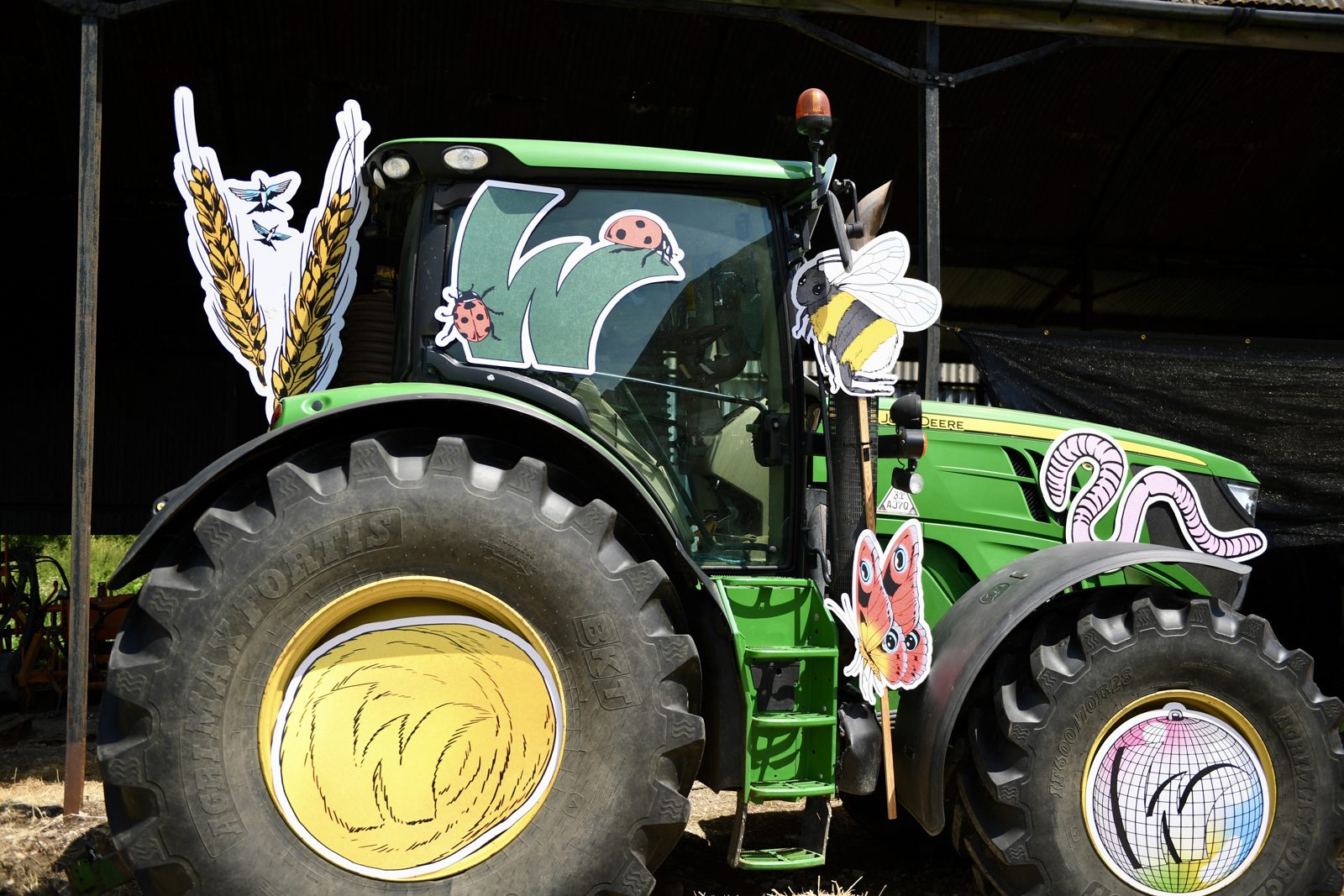 A John Deere tractor decorated with Wildfarmed artwork of wheat, bees and butterflies at Field Day